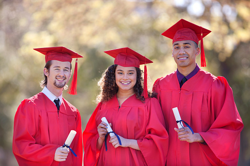 Ethnic group in red cap and gown on graduation day.