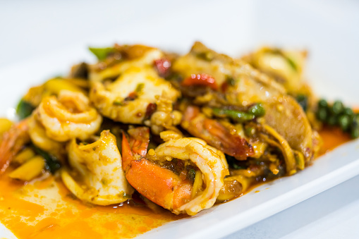 Stir fried spicy and delicious seafood on a white dish