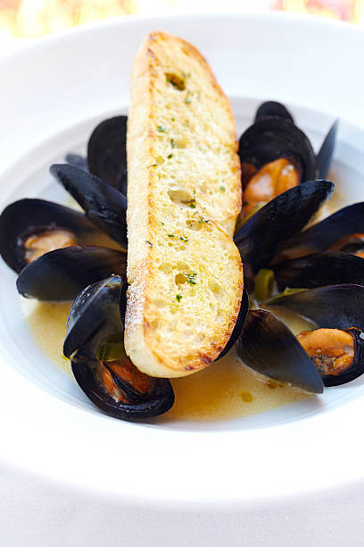 Bowl of muscles and parmesan crusted bread.  Vertical shot.