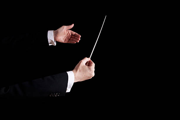 Conductor using his hands to orchestrate close up of a conductors hands with white background musical conductor stock pictures, royalty-free photos & images