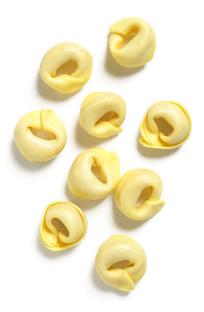 Uncooked squash tortellini isolated on white.