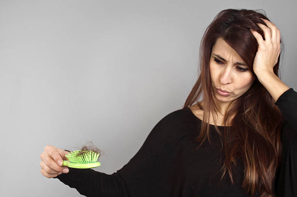 A long hair woman holding a green hairbrush full of hairs Balding problem women hand holding loss hair comb hairbrush hair stock pictures, royalty-free photos & images