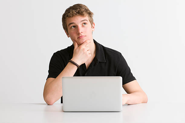 pensive student at working on laptop thinking student with laptop one teenage boy only stock pictures, royalty-free photos & images