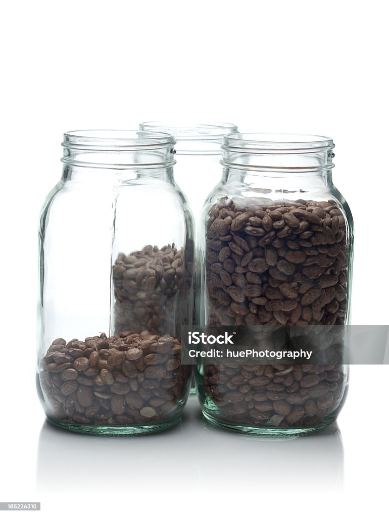 Rising Food Costs Isolated on white concept shot about rising food costs. Three jars of beans progressively fuller. Bean Stock Photo