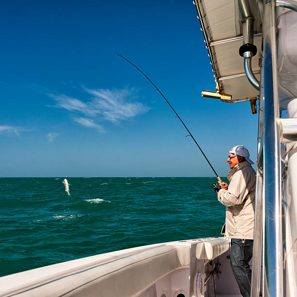 istock Senior man catching a fish on boat. 185226496