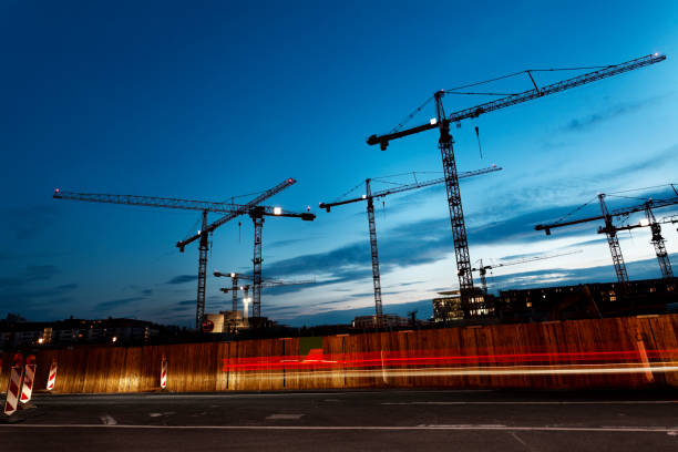 Cranes against blue sky at dusk Silhouettes of cranes against blue sky at dusk tower crane stock pictures, royalty-free photos & images