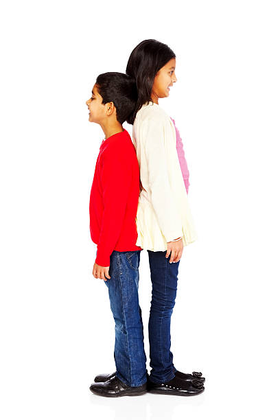 istock Cute little boy and girl comparing their heights on white 185226824