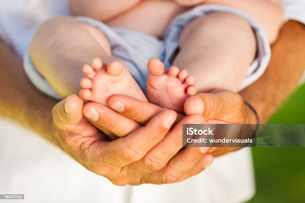 Father's Hands Holding Newborn's Feet Close-up of father's hands holding newborn's feet. Horizontal Shot. Please checkout our lightboxes for further images Adult Stock Photo