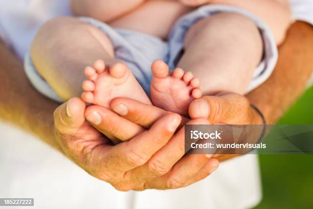 Fathers Hands Holding Newborns Feet Stock Photo - Download Image Now - Adult, Affectionate, Baby - Human Age