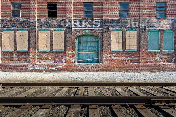 Abandoned Factory by Railroad Tracks