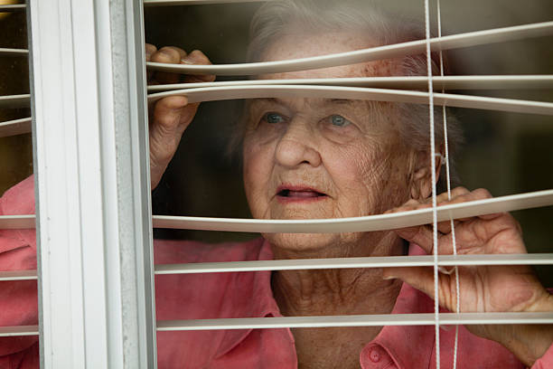 年配の女性 - blinds peeking looking window ストックフォトと画像