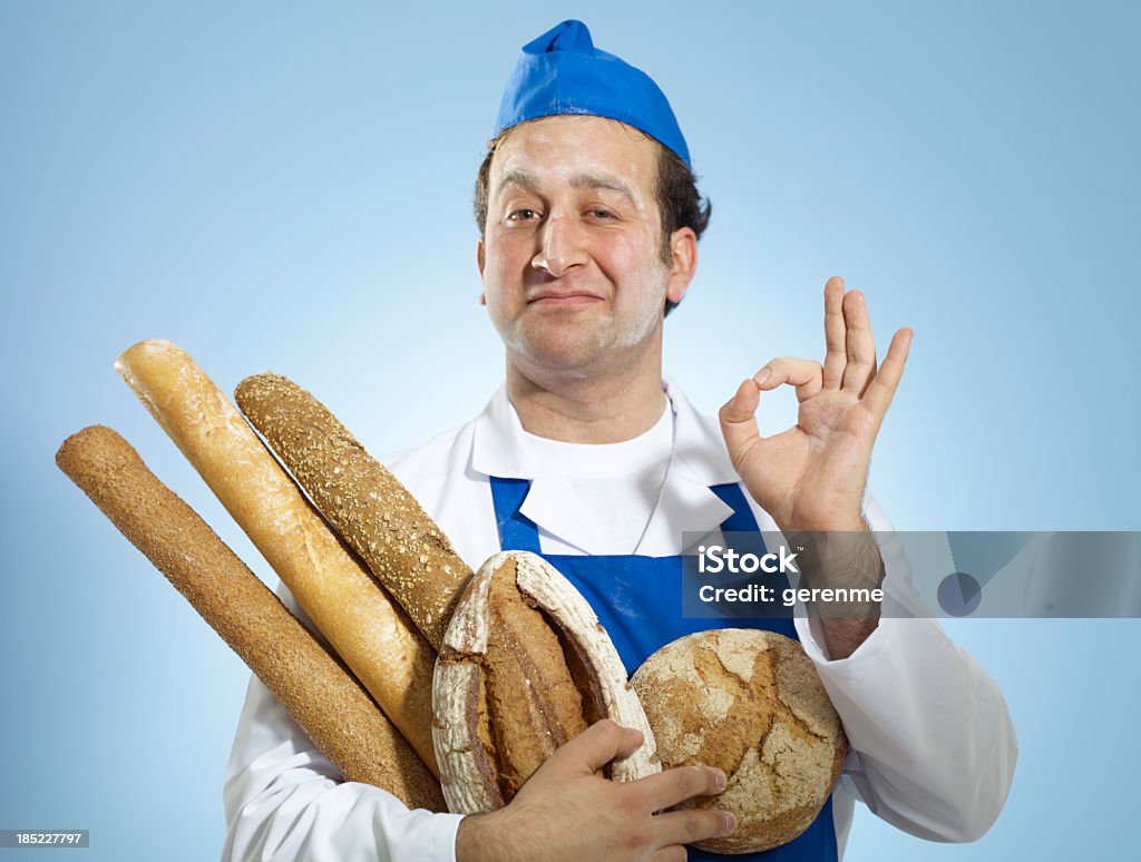 Young Baker Doing A-Okay Hand Signal Male baker wearing uniform and doing a-okay hand signal. Chef Stock Photo