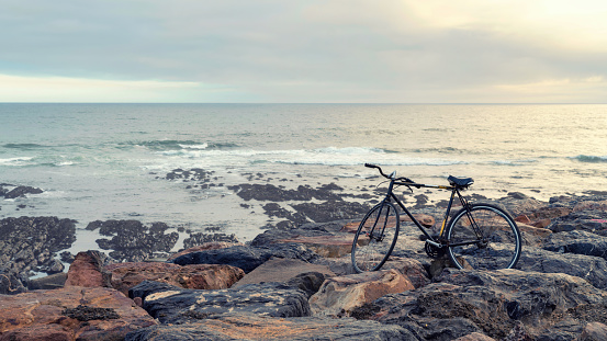 An aged bicycle by the rocky seashore. Concept of loneliness, remoteness and time.