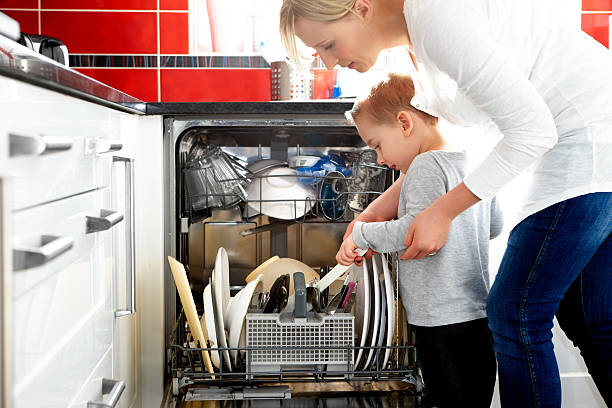 mother and son loading dishwasher - diskmaskin bildbanksfoton och bilder