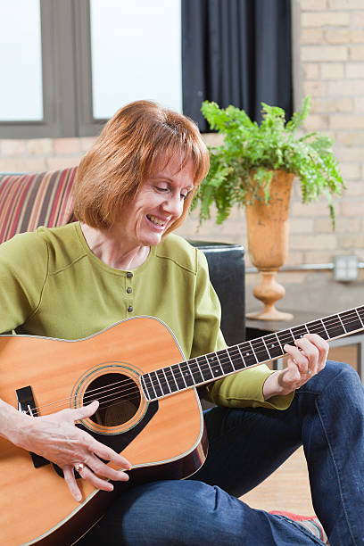 istock Middle Age Woman Playing Guitar in Her Home Vt 185228529