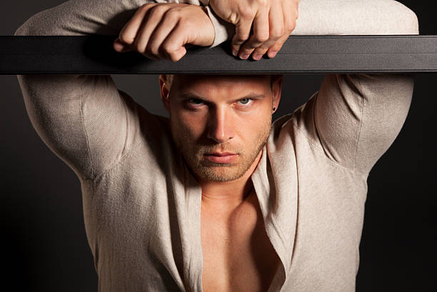 Attractive male model posing over grey background.