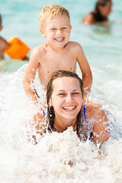 istock Mother and son having fun on sea waves 185228998