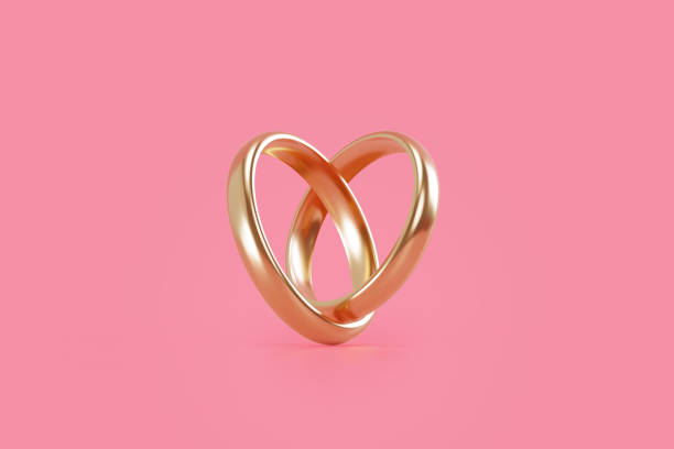 istock Gold Wedding Rings Forming A Heart Shape On Pink Background 1852297770