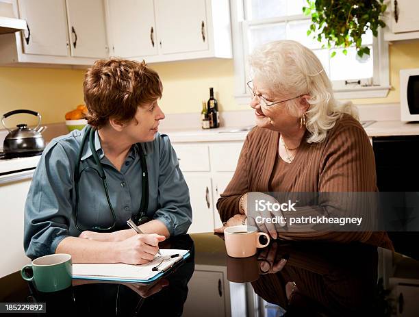 Foto de Médico Fazendo Uma Chamada De Casa e mais fotos de stock de Ensinar - Ensinar, Profissional de enfermagem, Cozinha