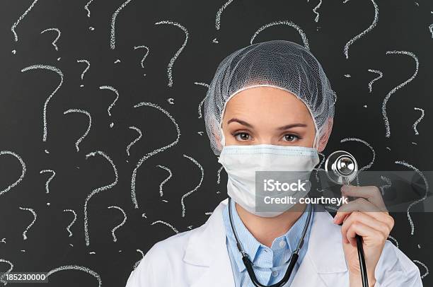 Female Doctor With Stethoscope In Front Of Question Marks Stock Photo - Download Image Now