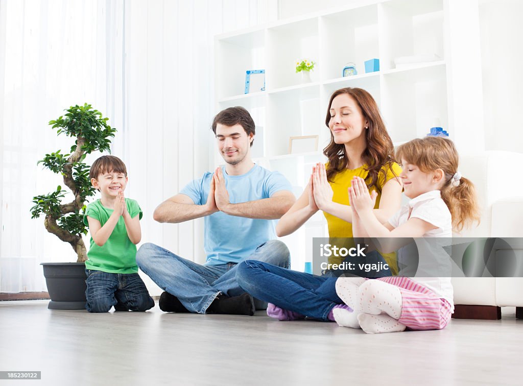 Familia con niños practicar yoga en su hogar. - Foto de stock de Familia libre de derechos