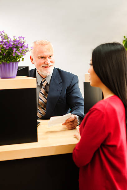 minorista banca cajero de banco ayudar a los clientes de la barra de vermont - bank teller bank check asian ethnicity fotografías e imágenes de stock