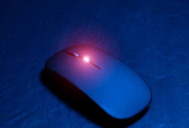 Black wireless minimalist mouse for laptop on the black background. Modern technology device.