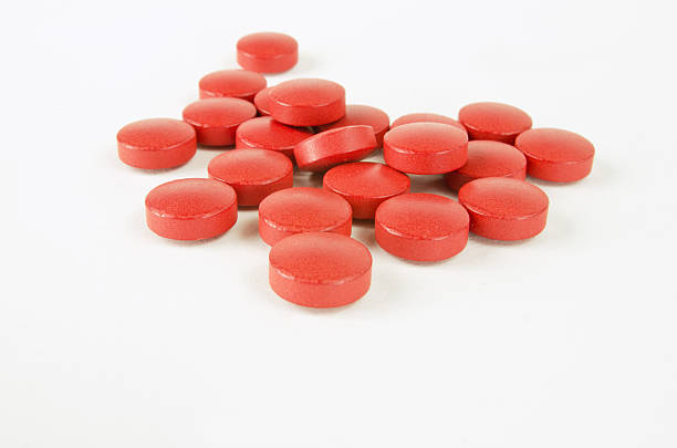 okrągłe, czerwone pigułki na białym - red pills zdjęcia i obrazy z banku zdjęć