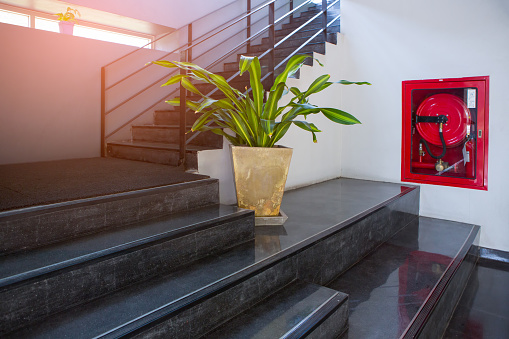 indoor concrete staircase with fire extinguisher and fire hose reel in the modern building