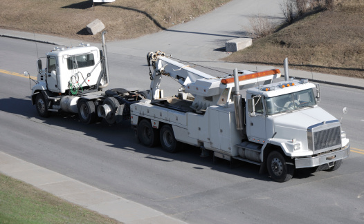 Big semi truck tow by heavy tow truck.