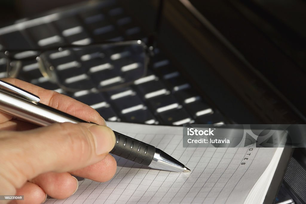 Las manos del hombre escribiendo en el cuaderno de un bolígrafo de información ordenador - Foto de stock de Abierto libre de derechos