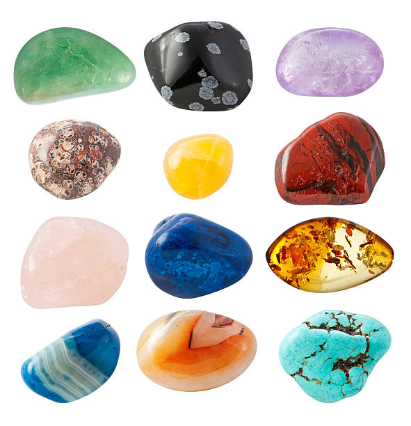 Assorted pebbles with different colors and patterns "Semi-precious Gems on white background. From left to right: Avanturine, Snow Obsidian, Amethyst, Leopard skin jasper, Yellow Calcite, Jasper, Rose Quartz, Dumortierite, Amber, Blue Agate, Agate, Turquoise." stone object stock pictures, royalty-free photos & images