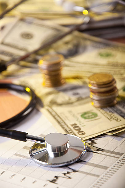 Doctor budgeting with stethoscope on table stock photo