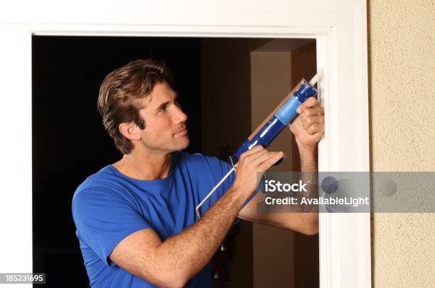 Caulking Gun Man In Blue Shirt Stock Photo - Download Image Now - Window, Energy Efficient, Residential Building