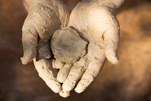 Close up of child's hand dirty with clay