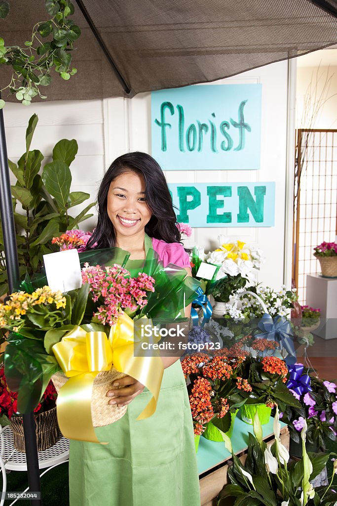 Young Asian florist outside retail flower shop. Small business owner. Young Asian florist outside her retail flower shop  MORE LIKE THIS... in lightboxes below. 20-29 Years Stock Photo