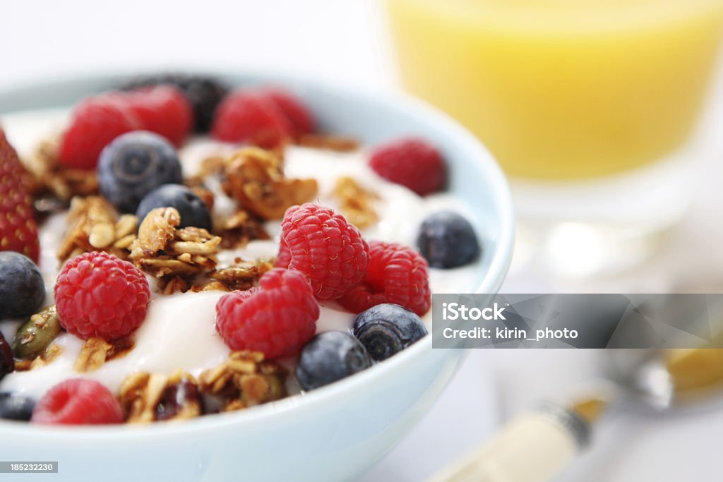 Yogurt with fresh berries and granola served in a white bowl breakfast table with yogurt Berry Fruit Stock Photo