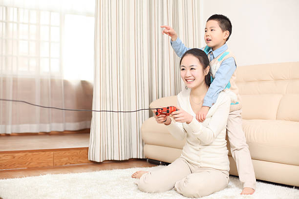 son is playing video games with his mother