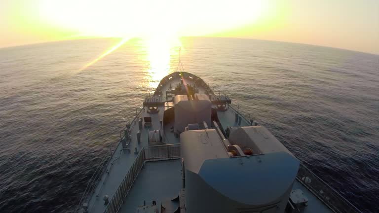 on board a warship heading into the sunset