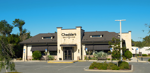 Ocala, Florida USA - October 22, 2023 Cheddars scratch kitchen is famous for Honey Butter Croissants, Homemade Chicken Pot Pie, Fried Chicken Tenders, and Smoked BBQ Ribs. building exterior with blue
