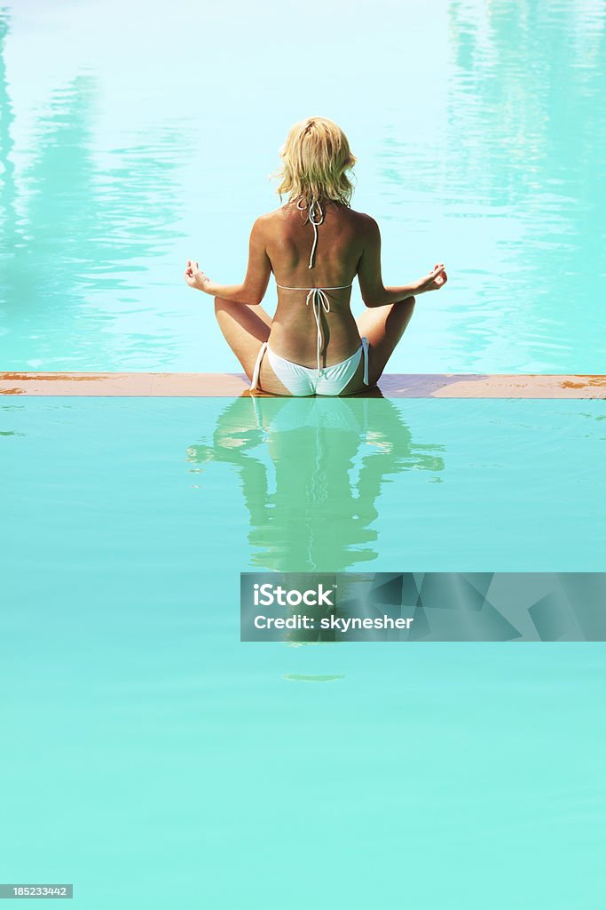 Traseira view.Woman Meditar na borda da piscina. - Royalty-free Adulto Foto de stock