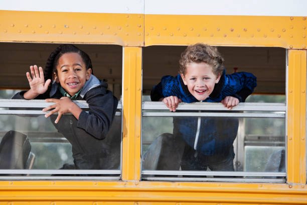 istock Children looking out school bus window 185234145