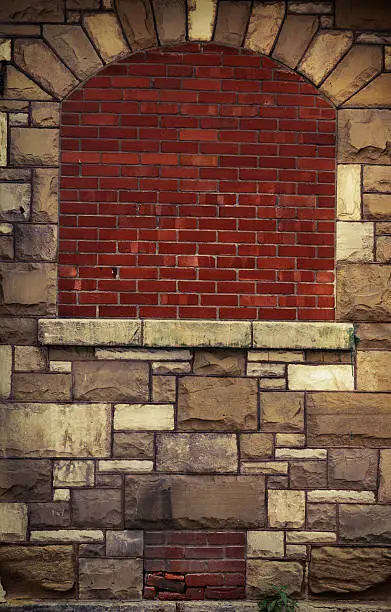 Bricked-up window in stone building wall