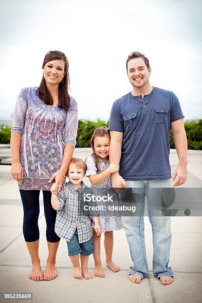 Photo libre de droit de Heureux Jeune Famille Tenant Les Mains En Position Debout Ensemble À Lextérieur banque d'images et plus d'images libres de droit de 2-3 ans