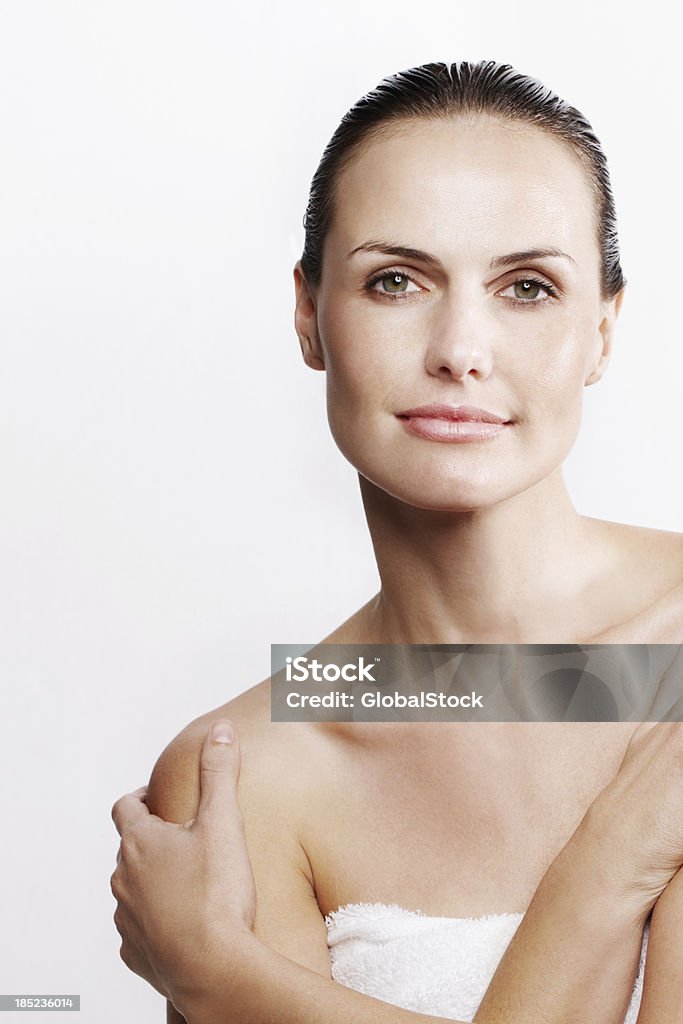 Woman wearing white towel with bare shoulders Beautiful woman with stunning skin looking fresh and clean - Isolated on white Women Stock Photo