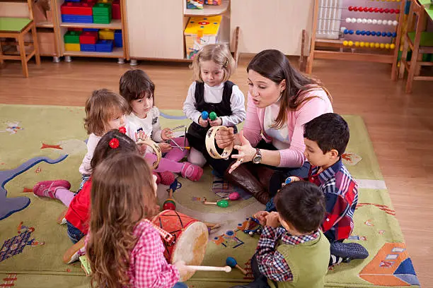 A group of preschool children in a music class.