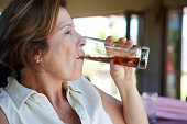 Attractive mature woman drinking soda