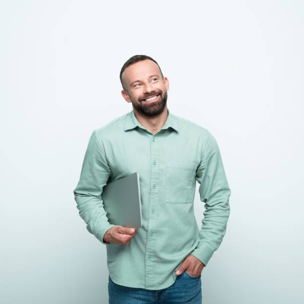 istock Portrait of friendly beared man holding laptop 1852373532