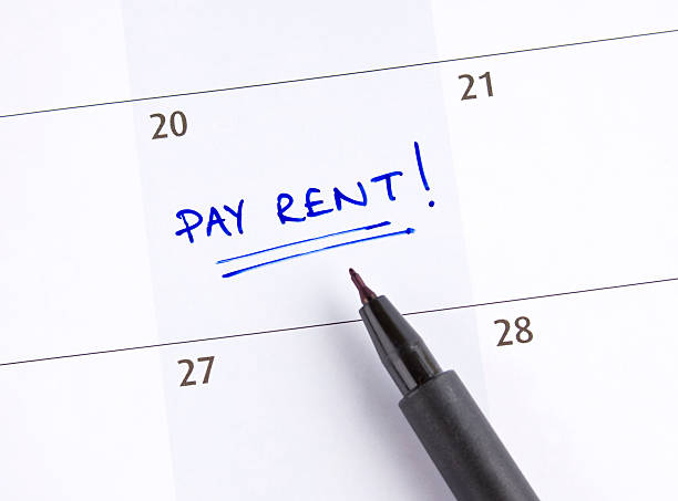 A calendar marked pay rent! on the 20th of the month stock photo