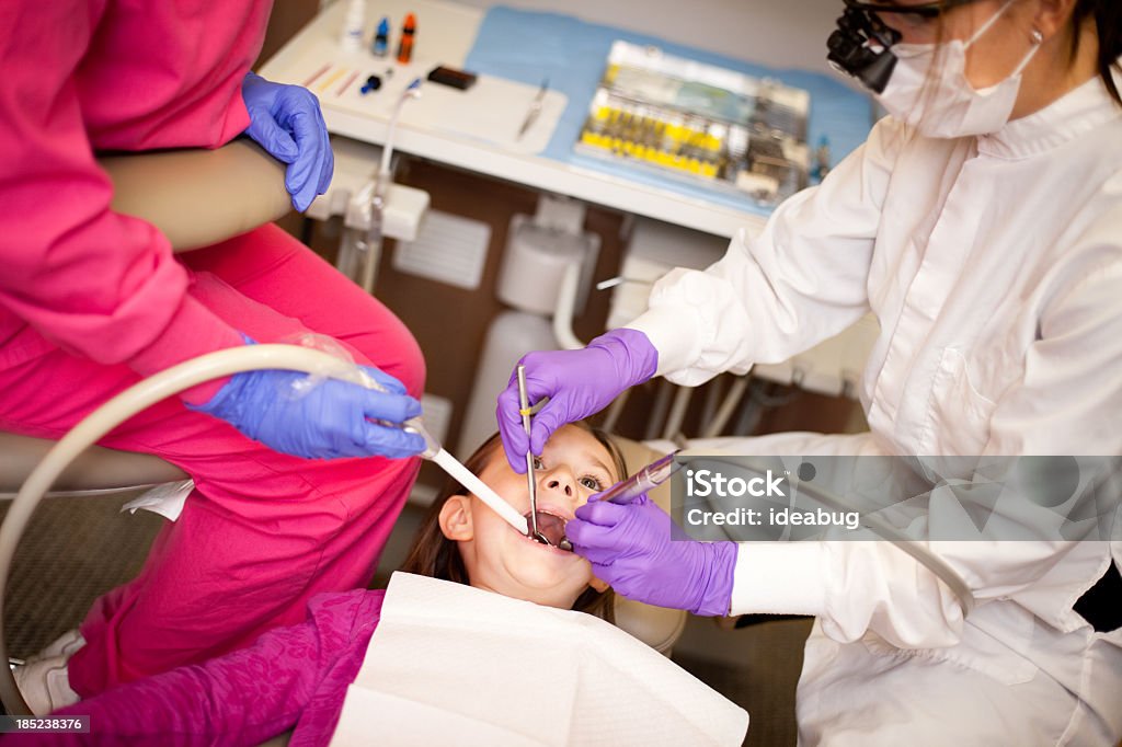 Garotinha recebendo Cárie dentária com Dentista cheio no escritório - Foto de stock de 6-7 Anos royalty-free